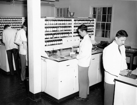 A historical photo of UMKC School of Pharmacy students working in the pharmaceutical lab.