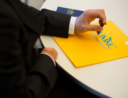 A closeup of a pharmacy student with their pharmacy folder laid on a table as they participate in the career fair.