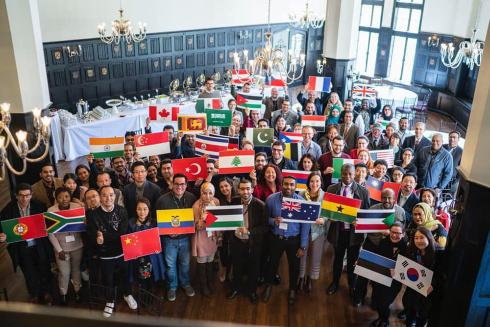Students from 42 different countries hold up their country's flag in the hall at Harvard Medical School while attending the Cancer Biology and Therapeutics Cancer Research program 